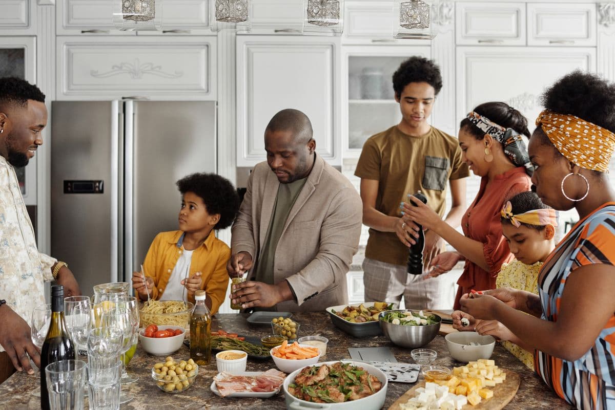 A family cooking a meal together at home across generations